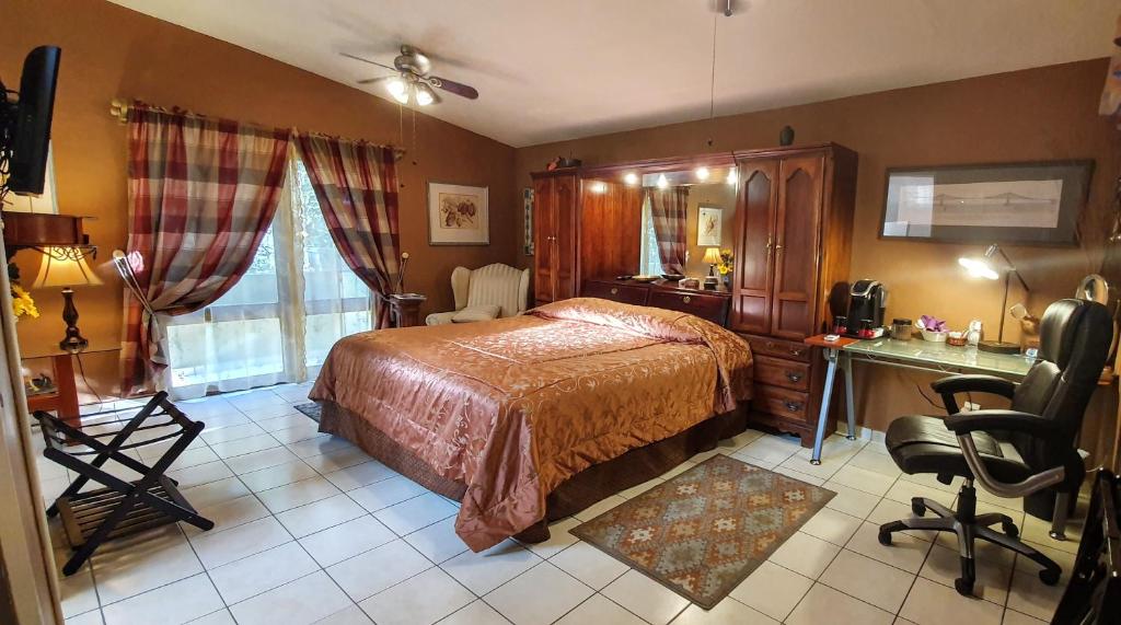 a bedroom with a bed and a desk and chair at Dickinson Guest House, Guadalajara Expo in Guadalajara