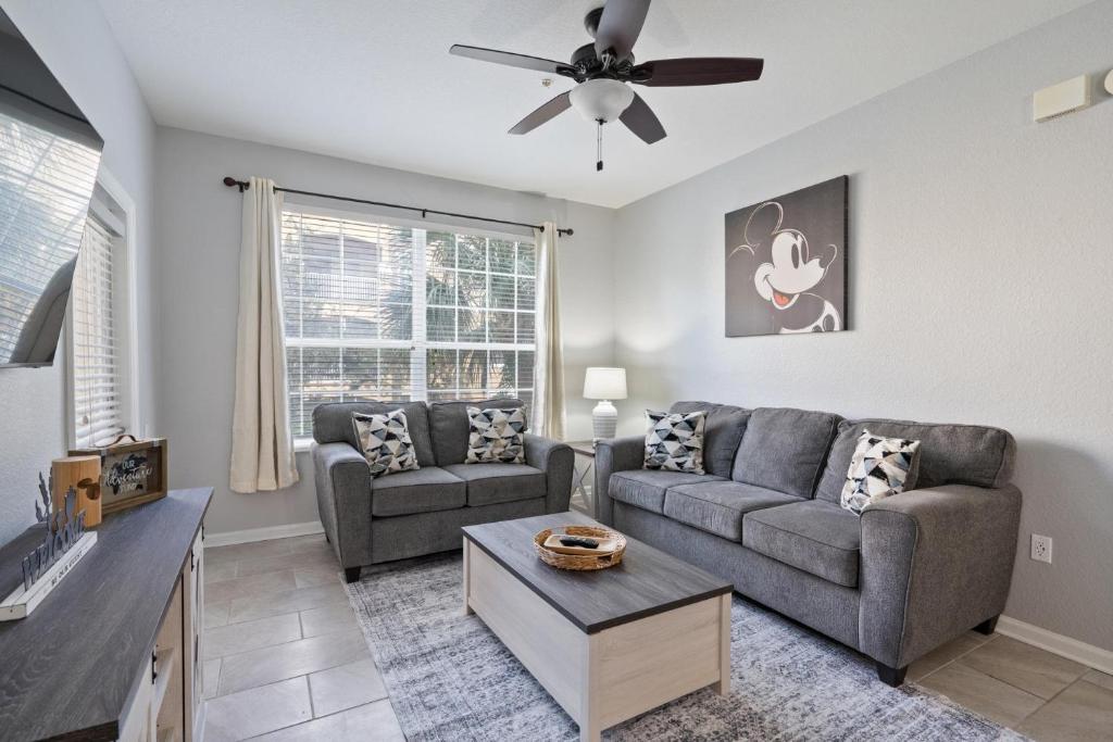 a living room with two couches and a ceiling fan at 7671 Comrow Unit 205 in Kissimmee