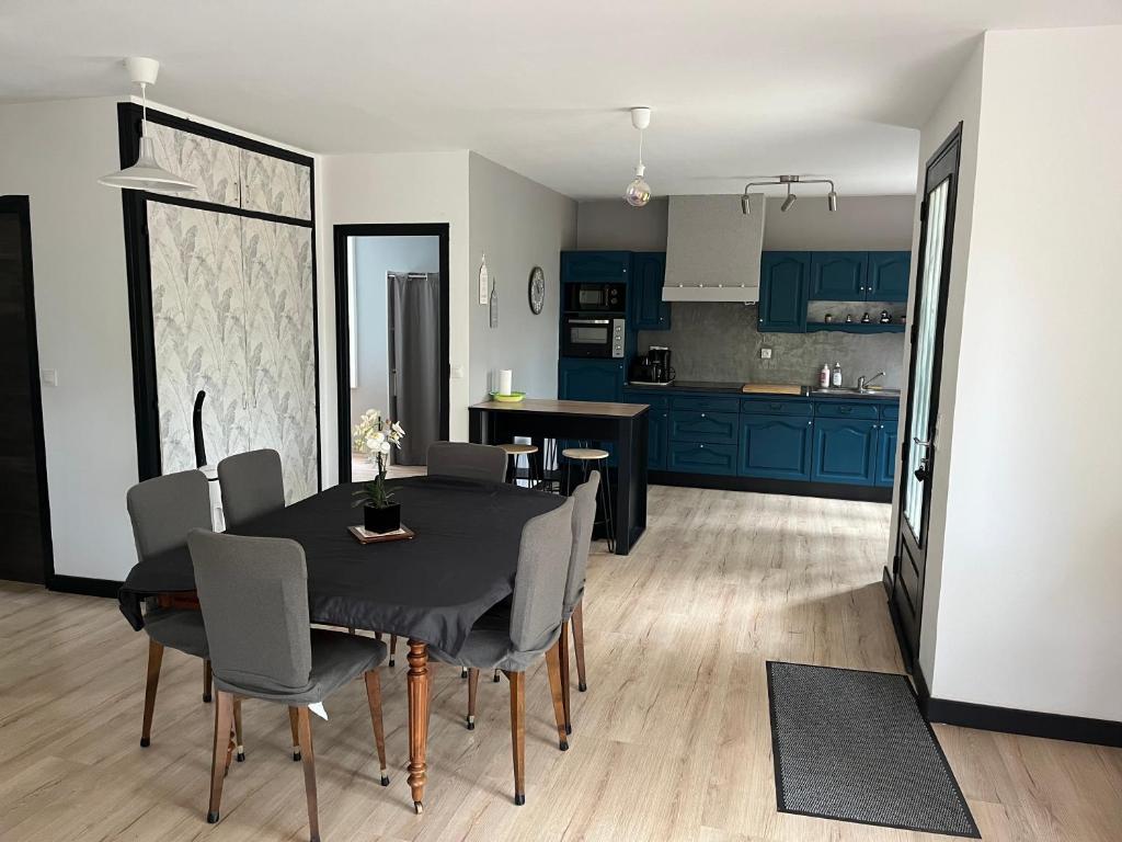 una cucina e una sala da pranzo con tavolo e sedie di La maison dans les bois a Crayssac