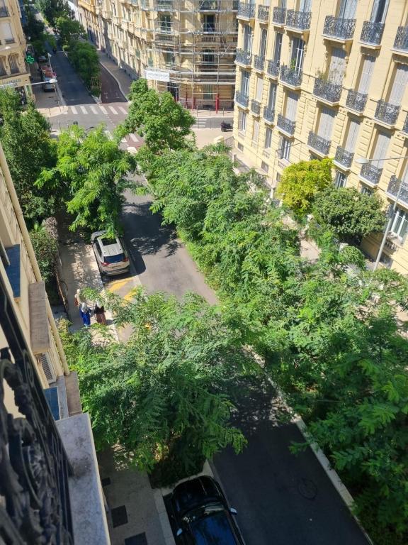 une vue aérienne sur une rue bordée d'arbres et de bâtiments dans l'établissement Beau T2 proche Negresco, à Nice