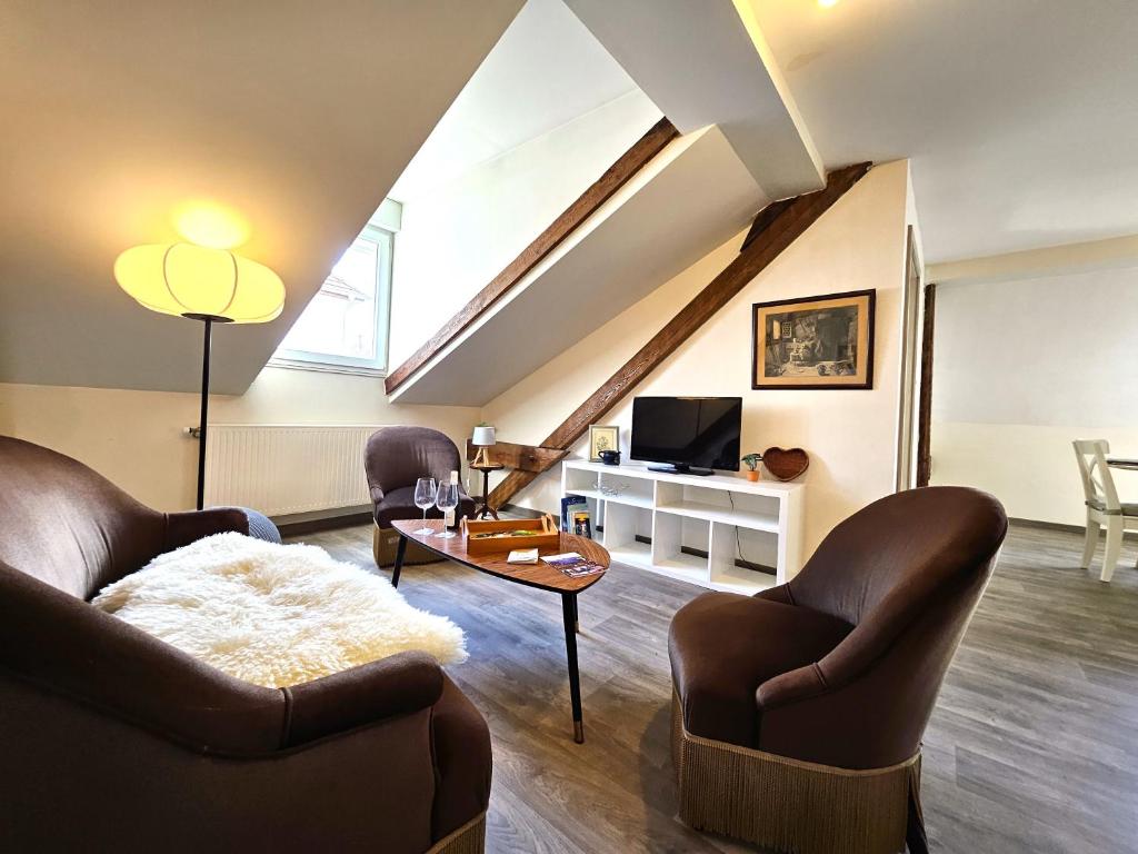 - un salon avec 2 fauteuils en cuir et une télévision dans l'établissement ThannT3-Centre Ville-Garage privé, à Colmar