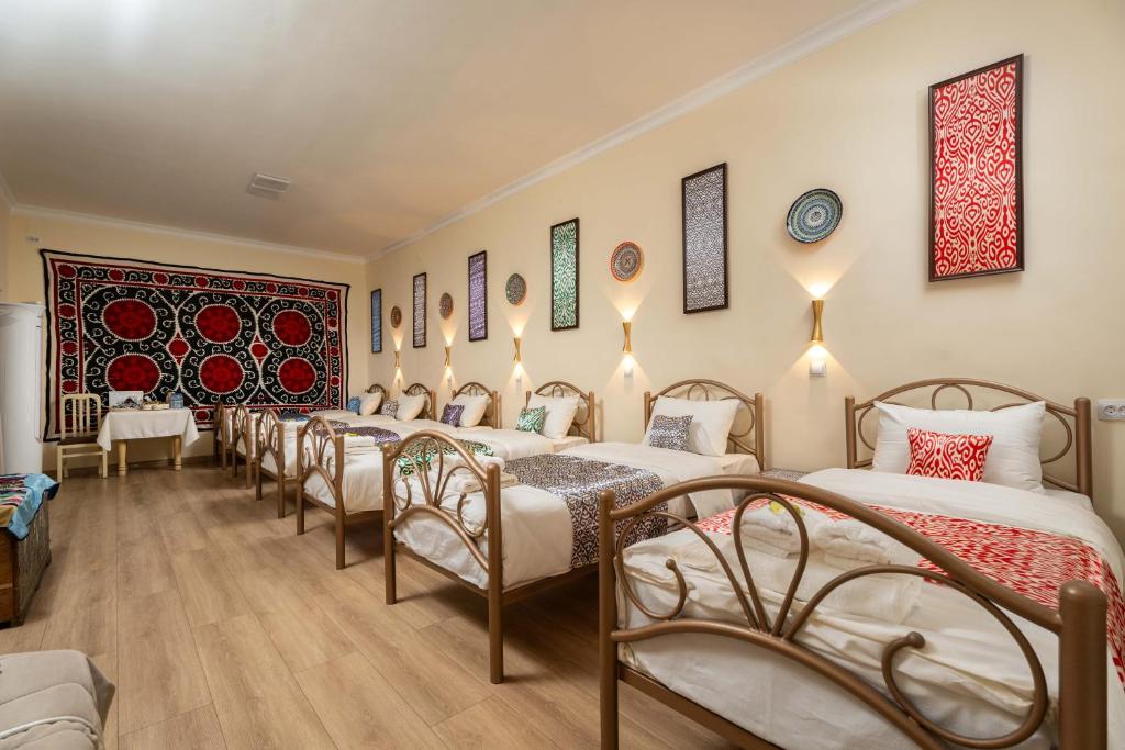 szereg łóżek w pokoju z lustrami w obiekcie Green Yard boutique guesthouse w Taszkiencie