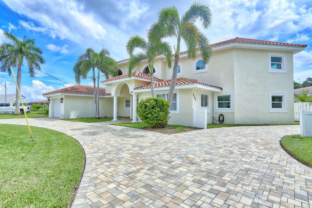 セント・ピート・ビーチにあるVilla At Bahia Shores-4BRの私道の手のひらが生える大きな白い家