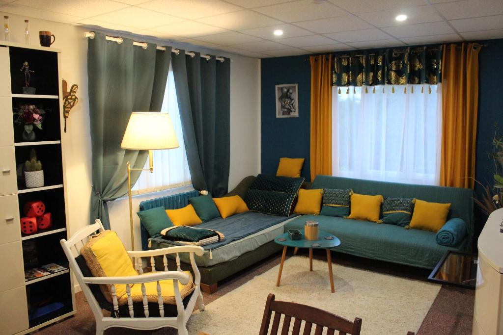 - un salon avec un canapé bleu et des oreillers jaunes dans l'établissement Les Conviviales de Seine-et-Marne, à Bouleurs
