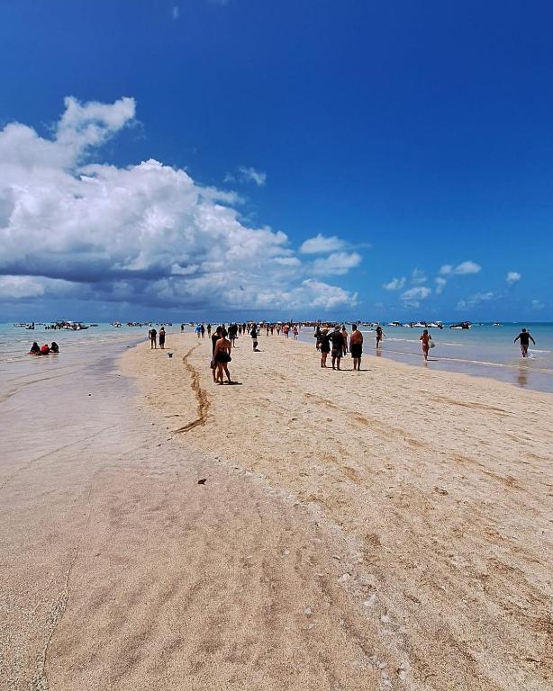 a group of people walking on a beach at Suite da Barra in Barra Grande