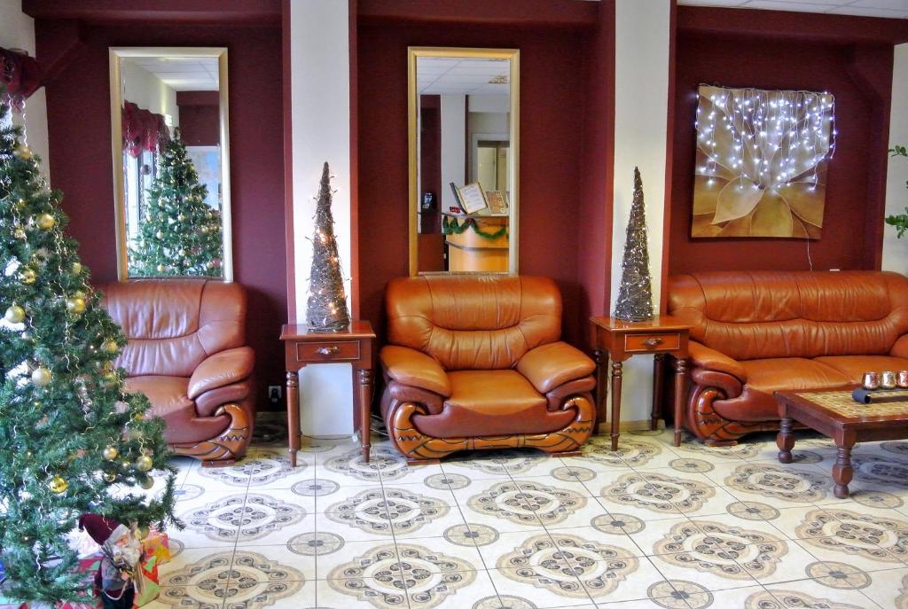 una sala de espera con sillas de cuero y un árbol de Navidad en Eurohotel en Maardu