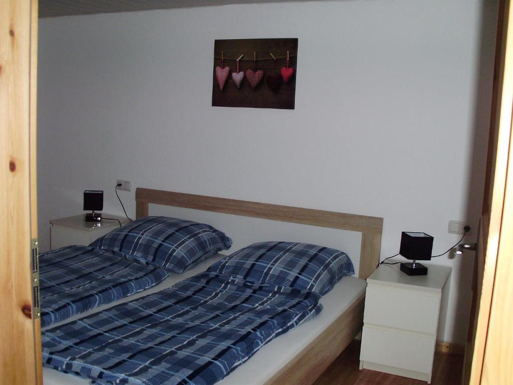 1 cama con 2 almohadas y una foto de zapatos rosados en Mühlenhof, en Stadtkyll