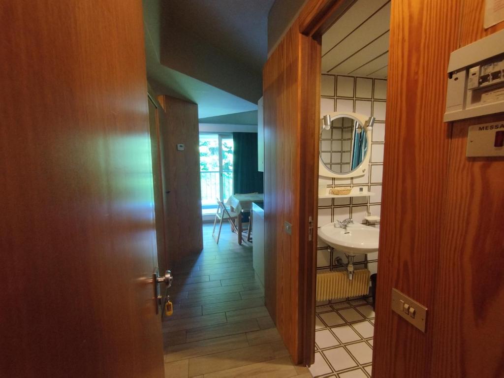 a hallway with a bathroom with a sink and a mirror at Marilleva1400 Residence Albaré hotel Solaria in Marilleva
