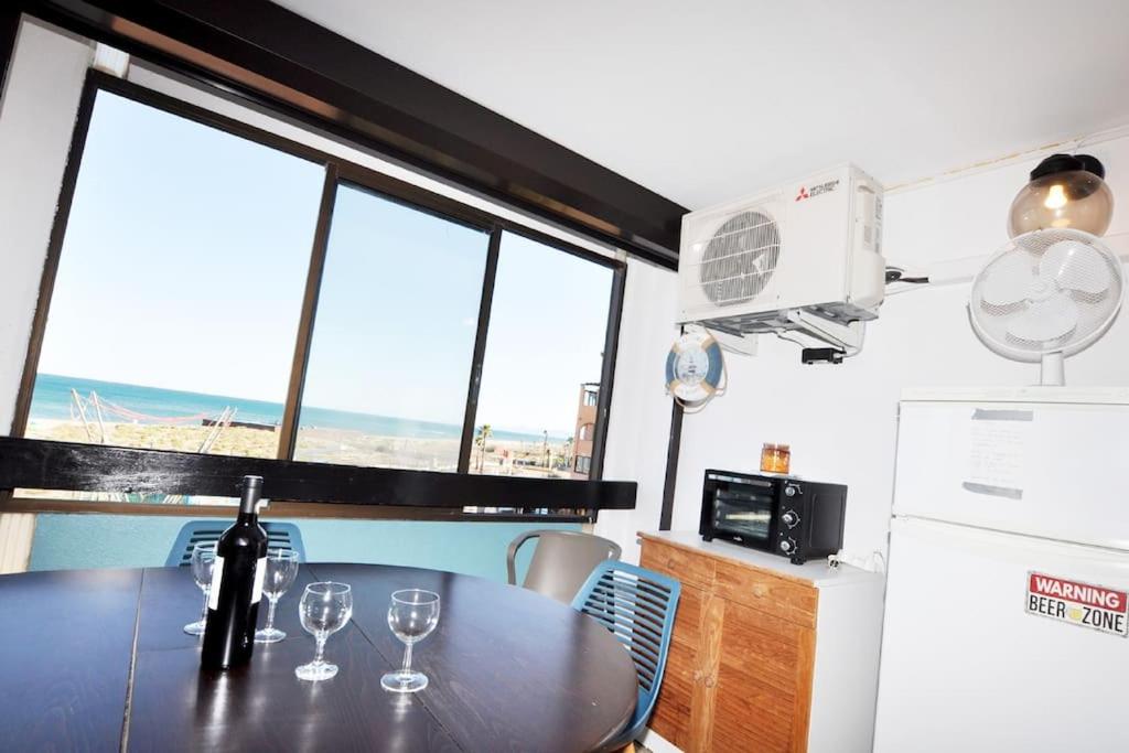 une cuisine avec une table avec des verres à vin dessus dans l'établissement Vue mer au Barcarès - Marché de Noël à pied, au Barcarès