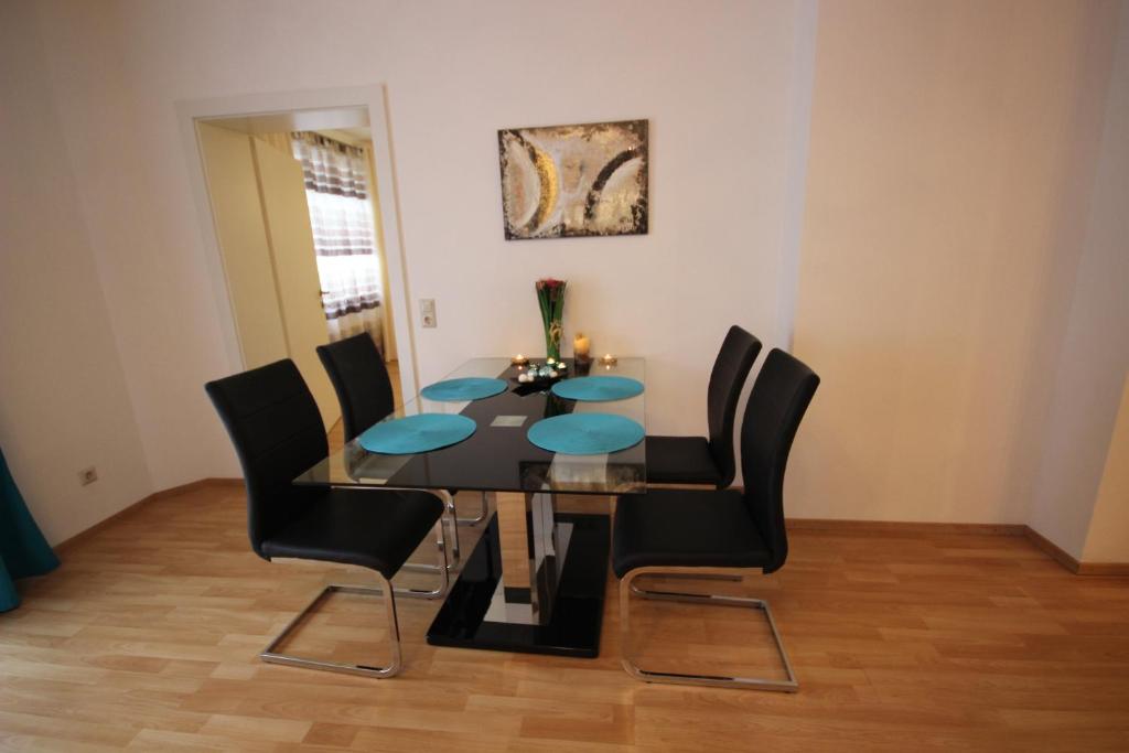 施泰尔罗曼施塔特斯太尔公寓的一间用餐室,配有黑桌子和黑椅子