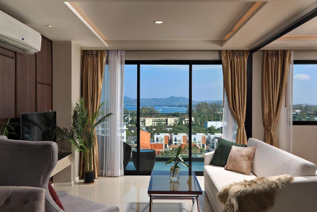 a living room with a couch and a large window at 3bdr SeaView Apartment in Surin Beach by Capital Pro in Phuket Town