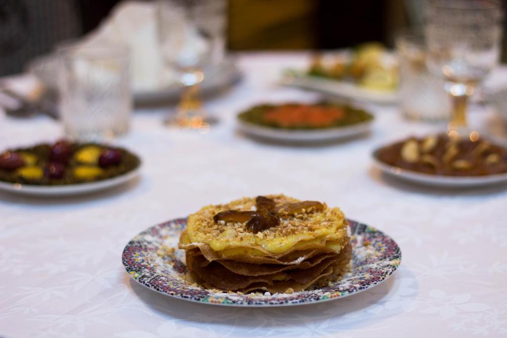 a table with a plate with a pastry on it at Riad Fes Kettani in Fez