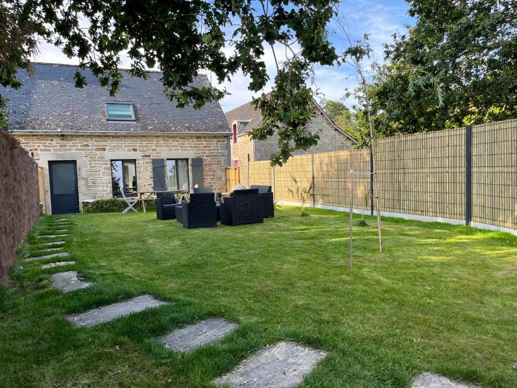 une cour avec une clôture et une cour avec un arbre dans l'établissement Maison bretonne typique plage des oiseaux à Fouesnant Beg Meil, à Fouesnant