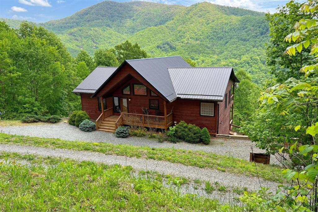 a log cabin with mountains in the background at Smoky Mountain High in Bryson City