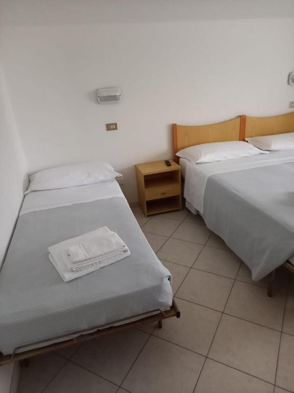 A bed or beds in a room at Hotel Serafini Misano Adriatico