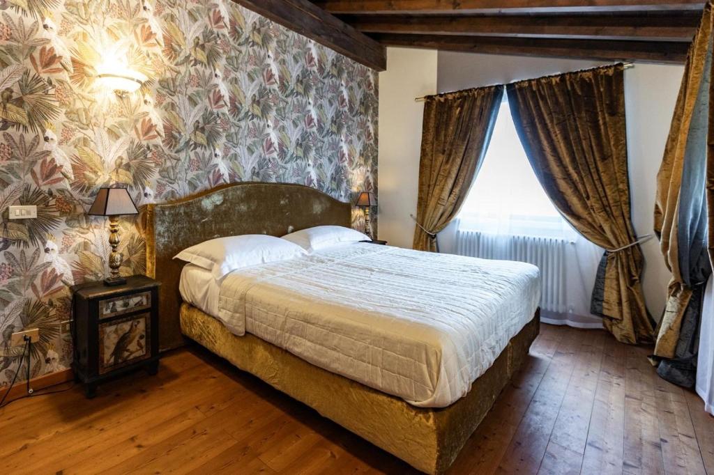 a bedroom with a large bed with a floral wallpaper at Corte Bioti in Pescantina