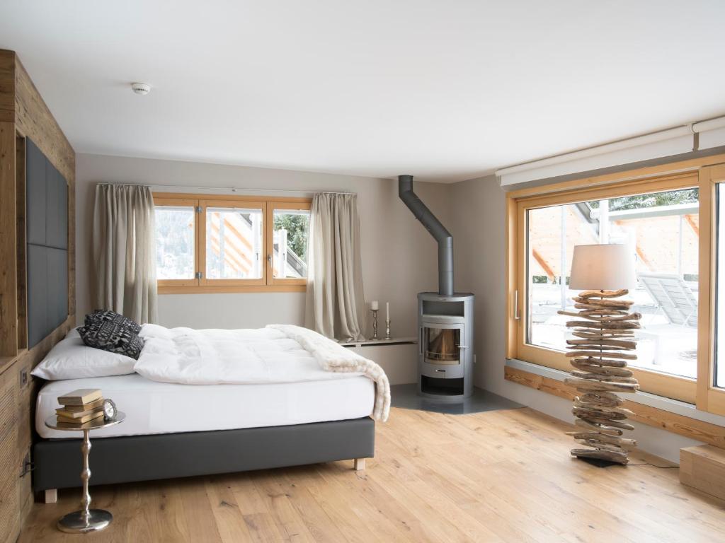 a bedroom with a bed and a fireplace and a window at Hotel Edelweiss in Davos