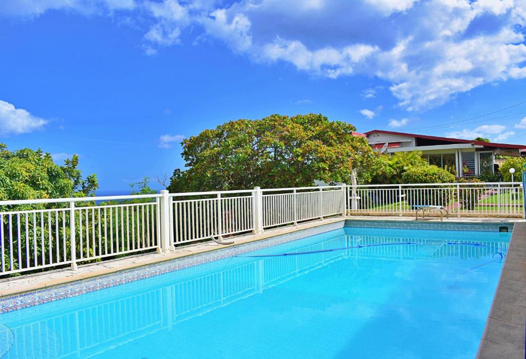 a swimming pool with a white fence around it at Lauramar Avocado - Vue Mer et Montagne in Le Morne aux Bœufs