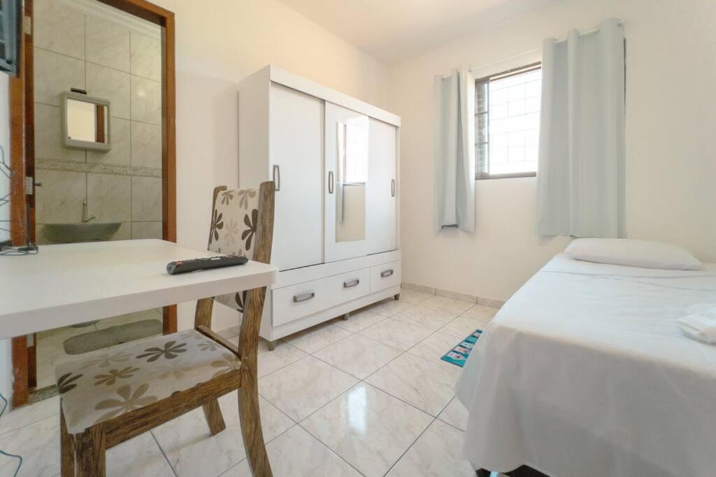 a bedroom with a bed and a desk and a mirror at Apartamento Econômico - GI07 in Maringá
