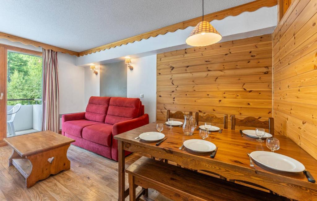 un salon avec une table et une chaise rouge dans l'établissement Résidence Les Hauts De Preclaux - Appartement en rez-de-jardin aux Orres 1800 MAE-3721, aux Orres