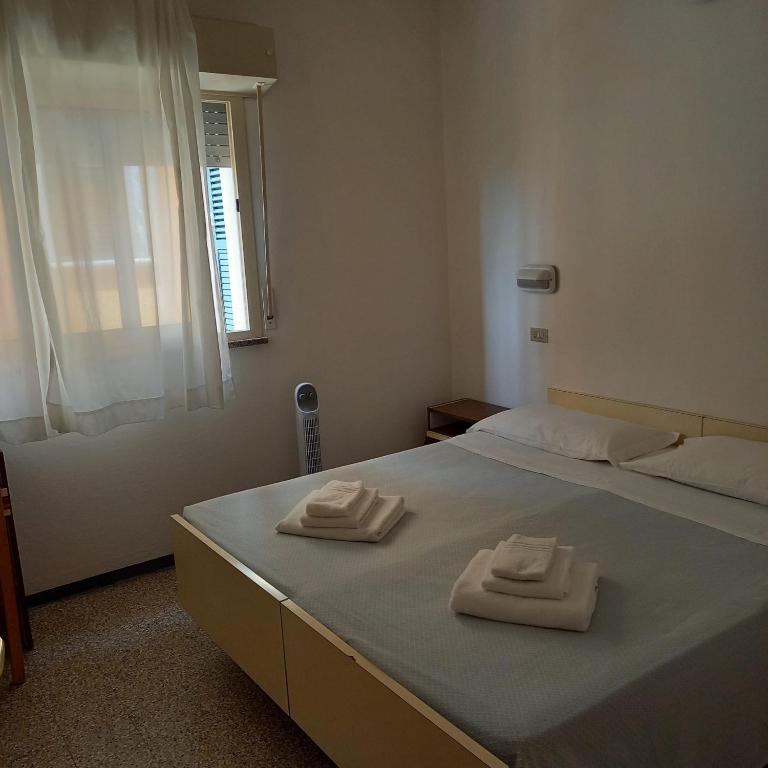A bed or beds in a room at Hotel Serafini Misano Adriatico