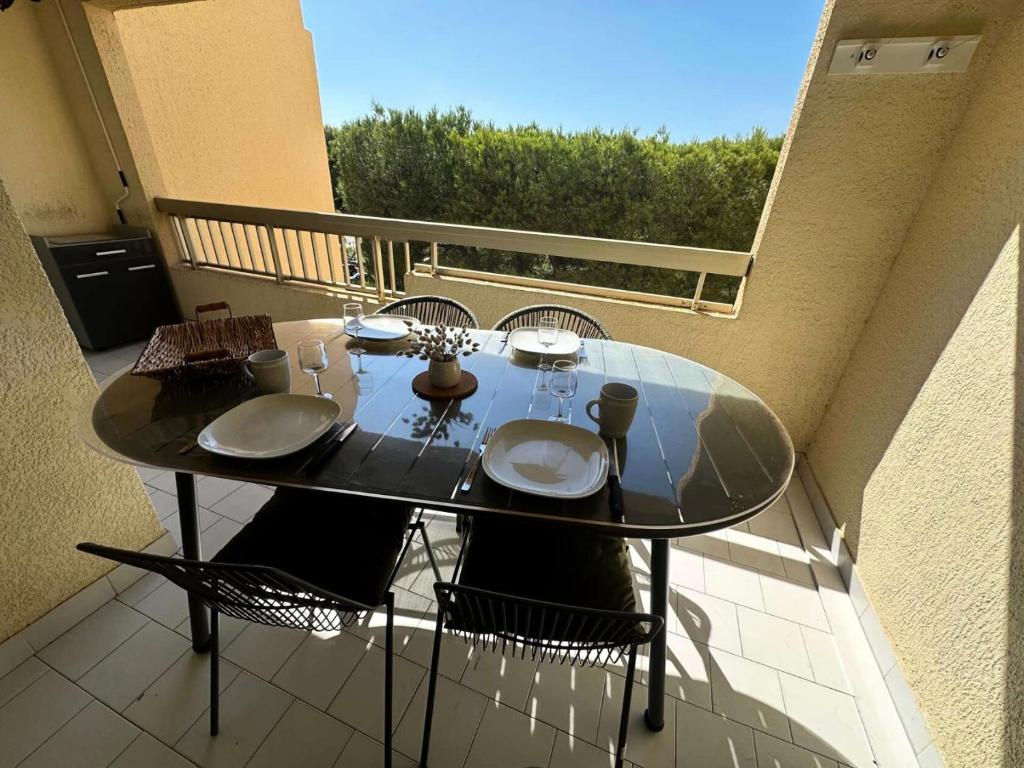 une table en verre et des chaises sur un balcon dans l'établissement Résidence Lauriers - Appartement T3 dans le Domaine de la Coudoulière a proximité de la mer MAE-7021, à Six-Fours-les-Plages