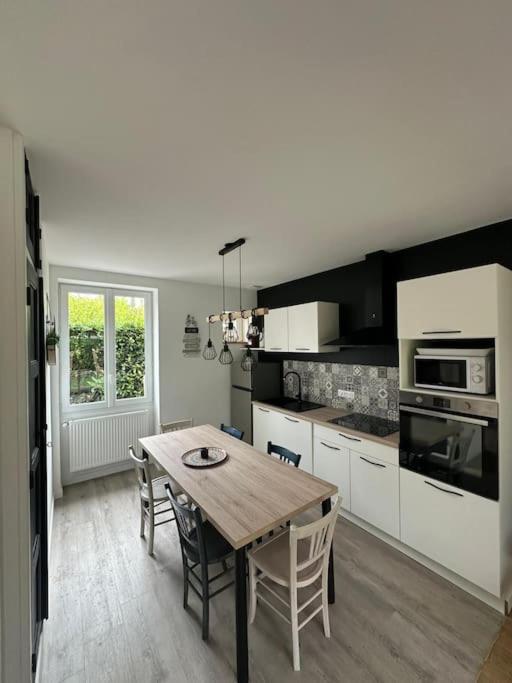 une cuisine avec une table en bois et une salle à manger dans l'établissement maison en ville Karine et Flavie, à Flacé-lès-Mâcon