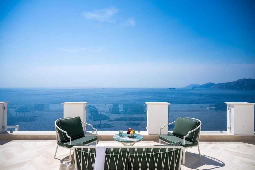 a patio with two chairs and a table with a view at Maison Lilly - Luxury Accommodation in Praiano