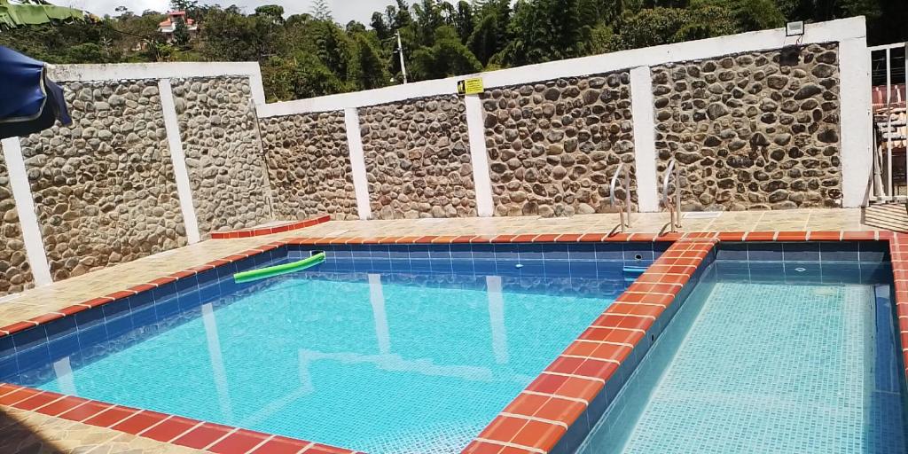a large swimming pool with a stone wall at alquilo en el queremal valle del cauca colombia in Papagalleros