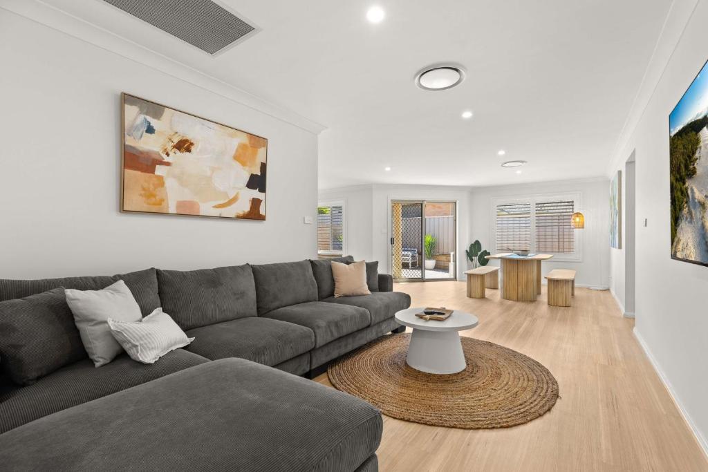 a living room with a couch and a table at Pipis Huskisson by Experience Jervis Bay in Huskisson