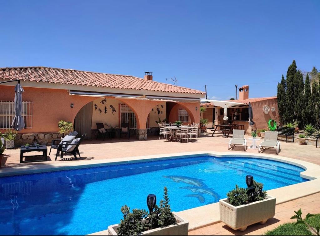 a swimming pool in front of a house at Villa Marovi Bonalba in Alicante