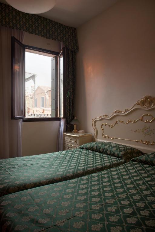 Postel nebo postele na pokoji v ubytování Hotel Commercio & Pellegrino