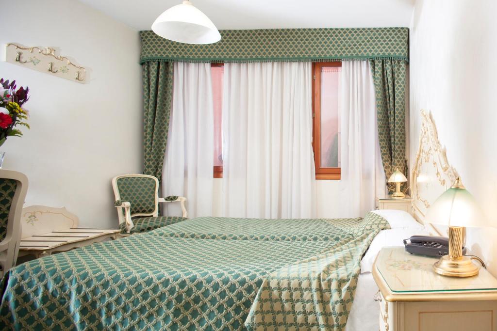 Postel nebo postele na pokoji v ubytování Hotel Commercio & Pellegrino