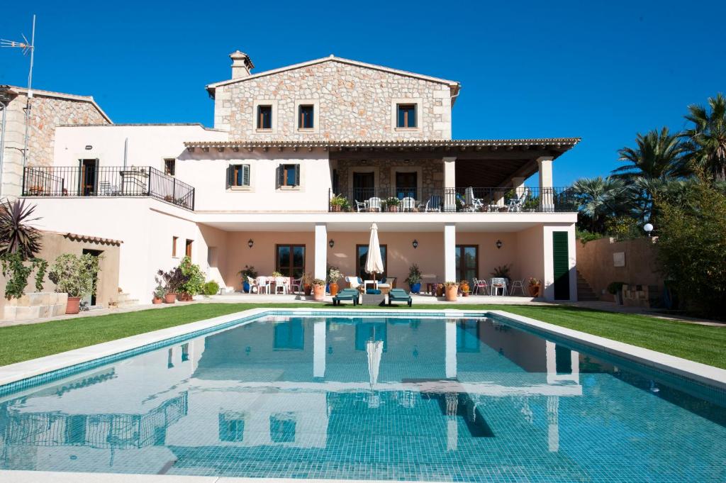 eine Villa mit einem Pool vor einem Haus in der Unterkunft Can Corem de Son Moix in Manacor