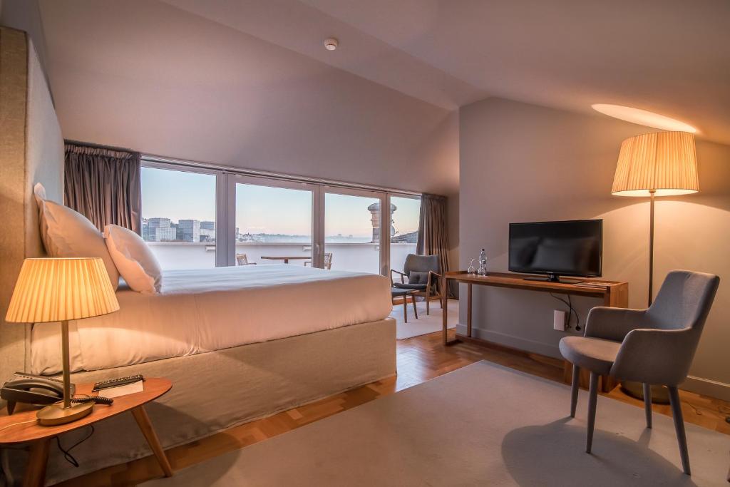 a hotel room with a bed and a large window at Villa Cascais Boutique Hotel in Cascais