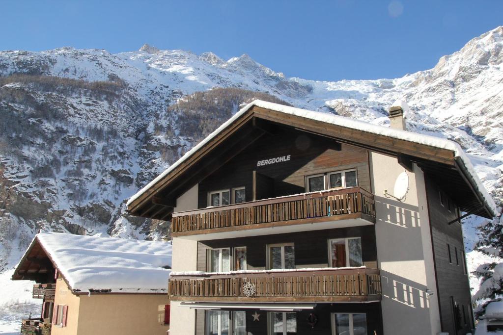 un edificio con balcón con montañas en el fondo en Ferienwohnungen Wallis - Randa bei Zermatt, en Randa