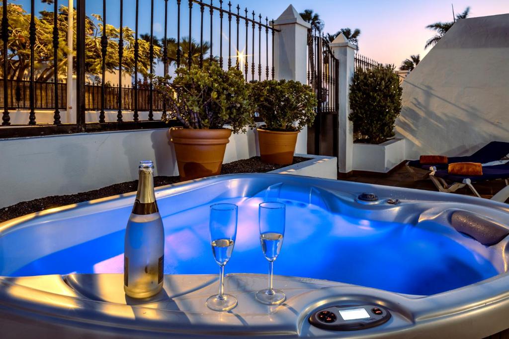 bañera de hidromasaje con 2 copas y botella de vino en Luxury House Tiati, en Tías