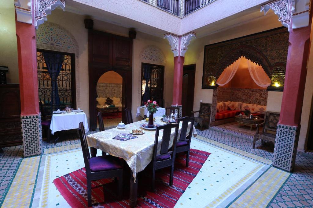 une salle à manger avec une table et un canapé dans l'établissement Riad Rêves D'orient & Spa, à Marrakech