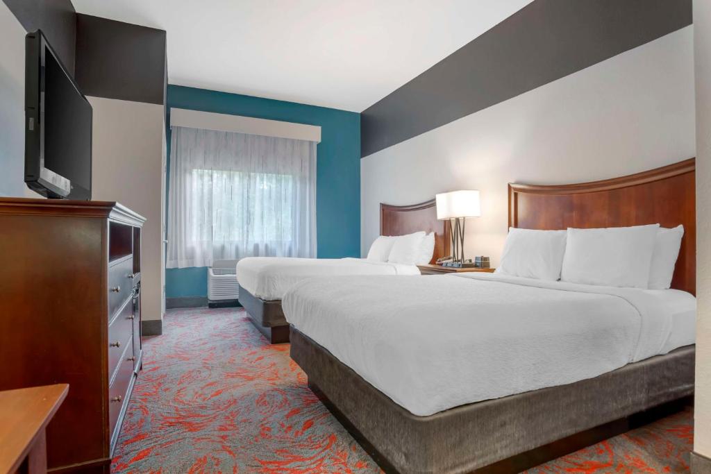 a hotel room with two beds and a flat screen tv at Best Western Plus Daphne in Spanish Fort
