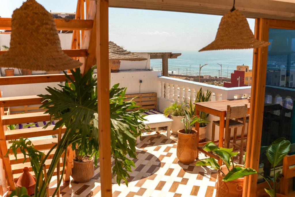 a balcony with a table and potted plants at Surf Break Morocco in Imsouane