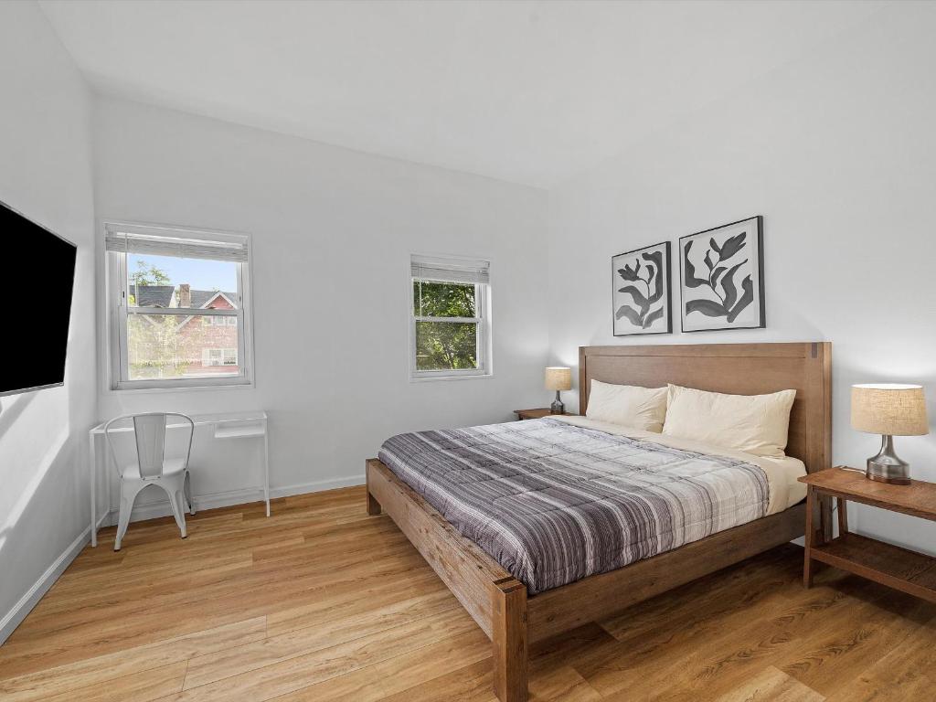 Un dormitorio con una cama y un escritorio y dos ventanas. en Bloomfield, Shadyside !B Spacious and Bright Private Bedroom with Shared Bathroom, en Schenley Heights