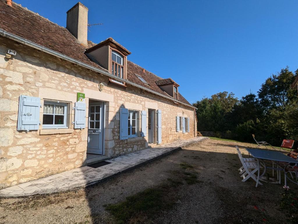 una vecchia casa in pietra con un tavolo da picnic di fronte di Maison rénovée au cœur du Parc Naturel de la Brenne avec jardin et terrasse - FR-1-591-44 a Saint-Aigny