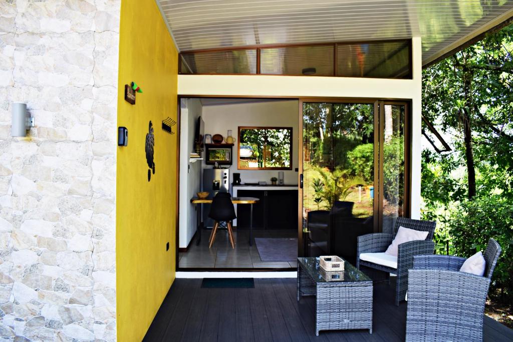 a house with a yellow wall and a patio at Villa Buenaventura in San Ramón