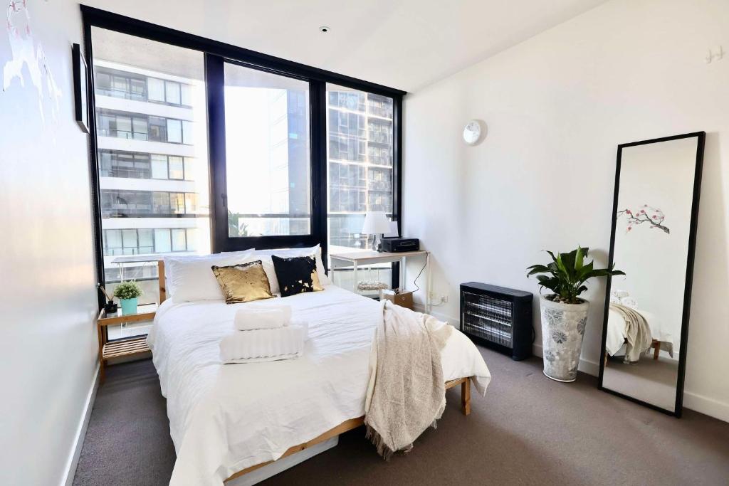 a bedroom with a large bed and a large window at Entire 1 BR Southbank Apartment - Gym Pool Sauna 1 step to Crown Casino in Melbourne