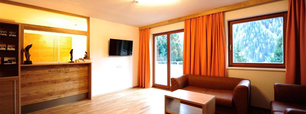 a living room with a couch and a tv at Apart Alpenglüh´n in Spiss