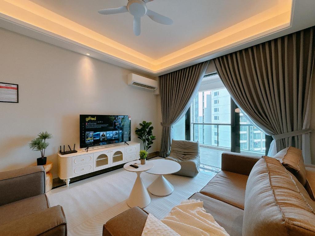 a living room with a couch and a tv at R&F Princess Cove Seine Region by Lions Bay in Johor Bahru