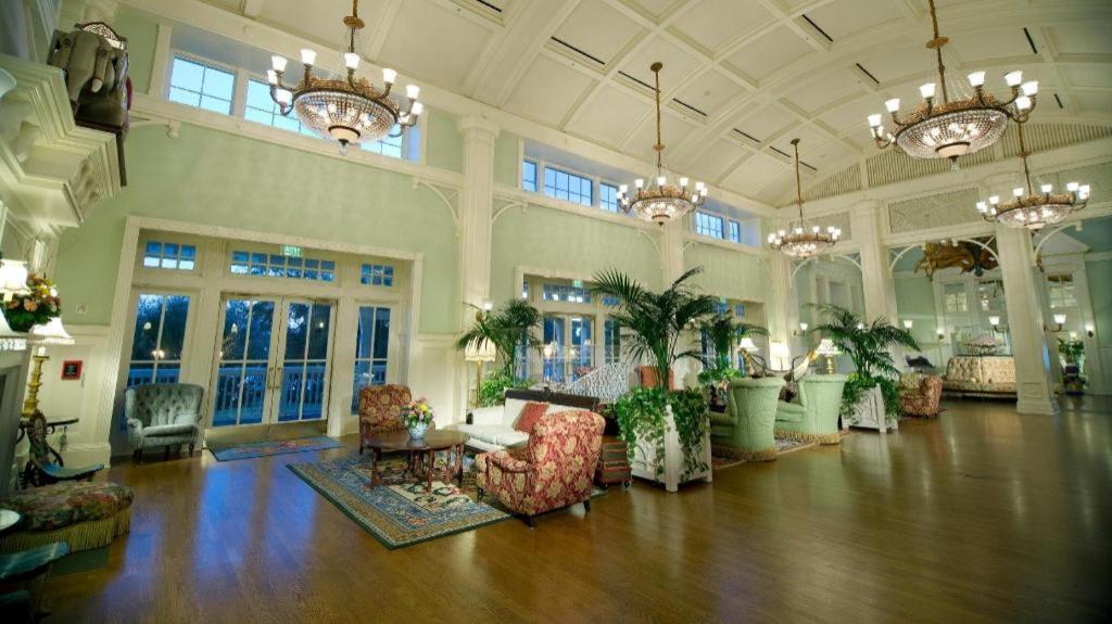 a large living room with chandeliers and tables and chairs at Disney's Boardwalk Inn in Orlando