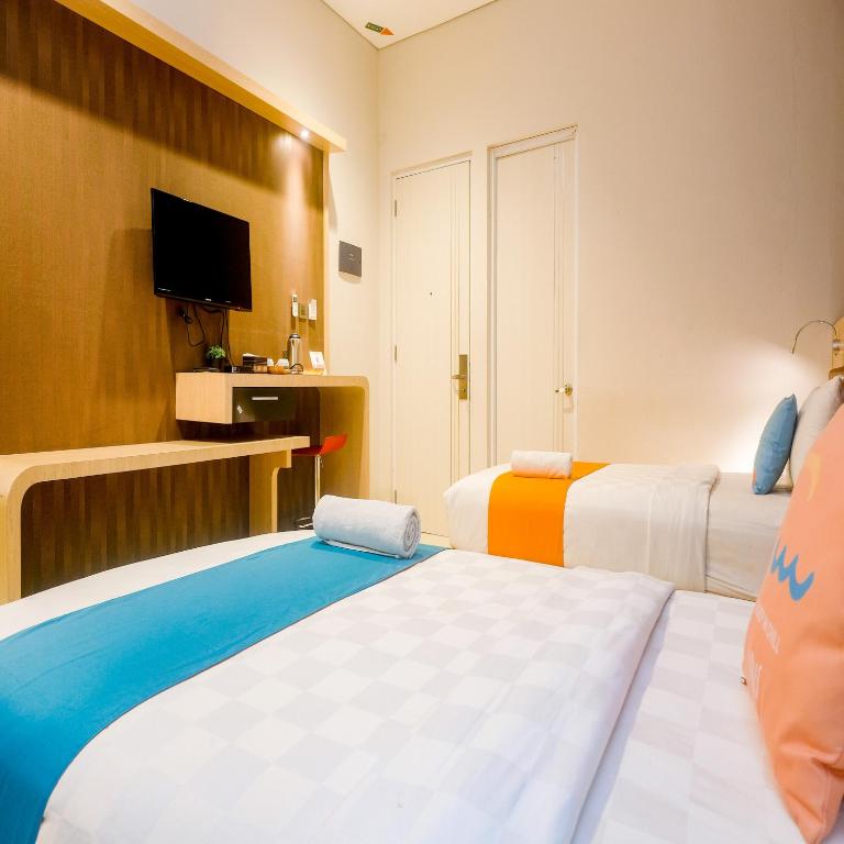 Postel nebo postele na pokoji v ubytování Sans Hotel Grand Omah Sastro Yogyakarta