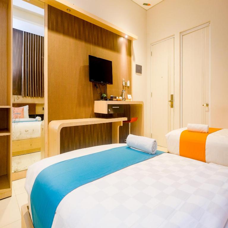 Postel nebo postele na pokoji v ubytování Sans Hotel Grand Omah Sastro Yogyakarta