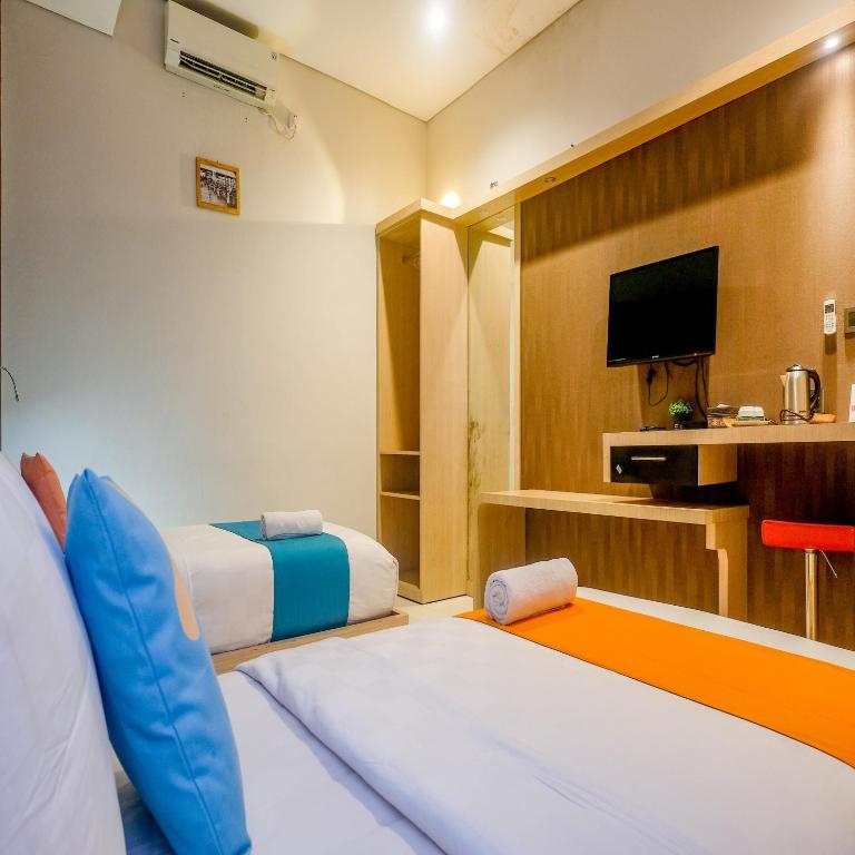 Postel nebo postele na pokoji v ubytování Sans Hotel Grand Omah Sastro Yogyakarta